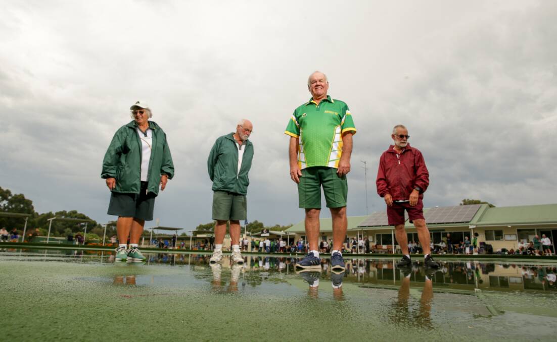 DECISIONS: The pennant committee - Marian Treweek, Ian Prout, Daryl Andrew and Barry Bowen - inspect the rain-soaked Terang greens on Tuesday. Play resumed in the afternoon. Picture: Chris Doheny
