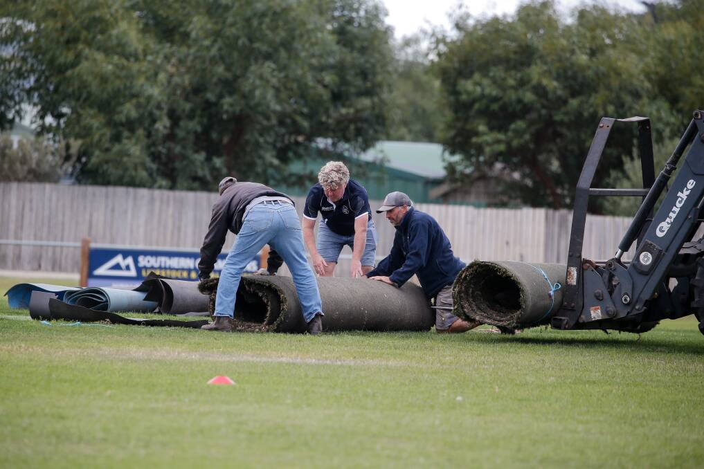 Volunteers help roll the wicket at Allansford earlier this year. Picture by Anthony Brady 