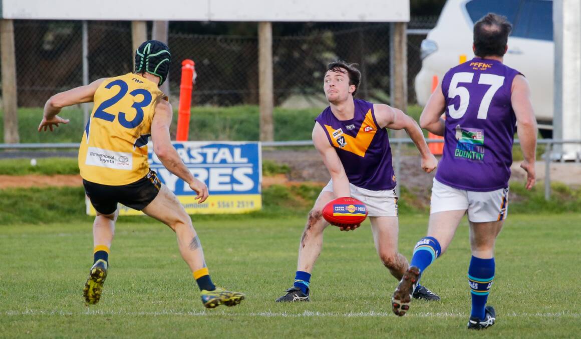 WORKHORSE: Port Fairy's George Swarbrick dishes off a handball against North Warrnambool Eagles. Picture: Anthony Brady 