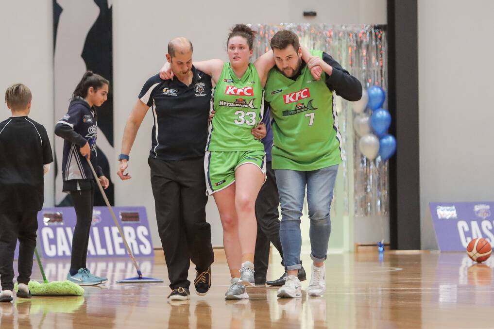 Support: Warrnambool Mermaids' Molly McKinnon is carried off court after injuring her knee. 
