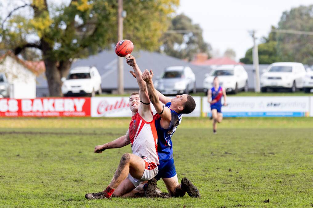 South Warrnambool's Isaac Thomas and Terang Mortlake's Will Kain reach for the ball while on the ground. Picture by Anthony Brady 