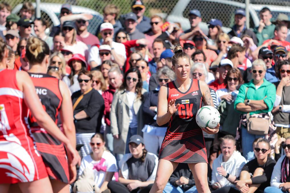 A large crowd watches Cobden's Remeny McCann in the open netball grand final. Picture by Anthony Brady 