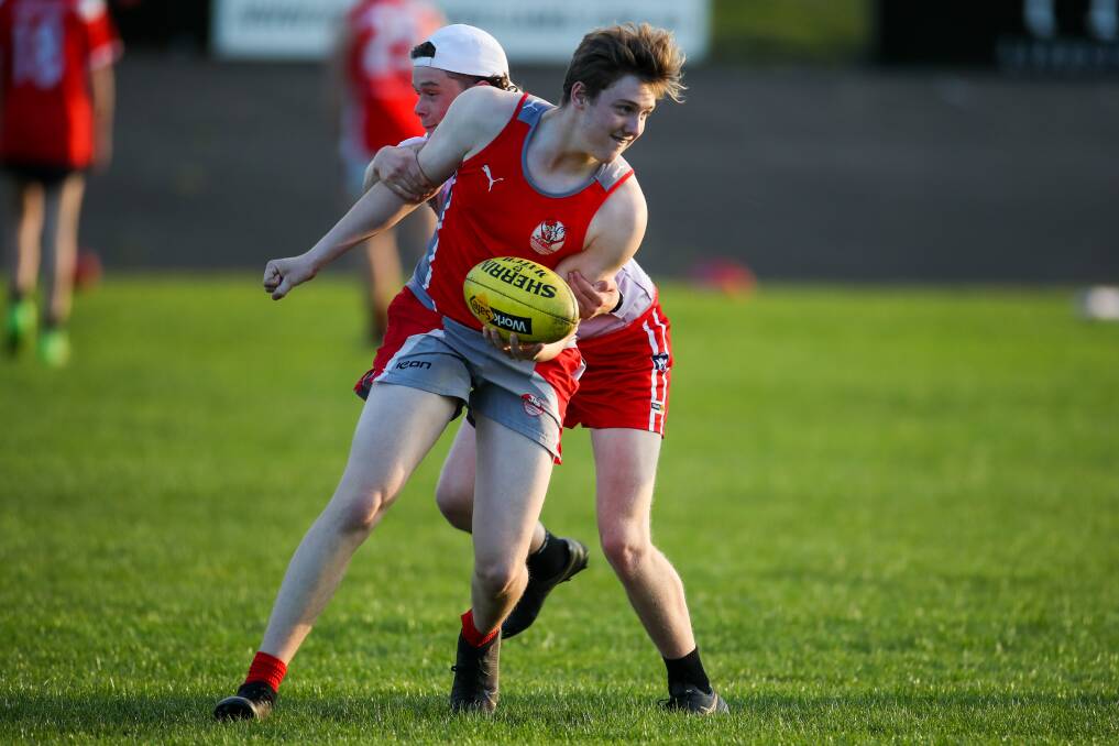 UNDER PRESSURE: Charlie Lynch tries to dish off a handball as he's tackled at South Warrnambool under 16 training. Picture: Morgan Hancock 