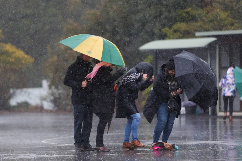 RAIN, HAIL OR SHINE: Supporters brave the cold, wet conditions during a netball match in Camperdown last year. Picture: Morgan Hancock 