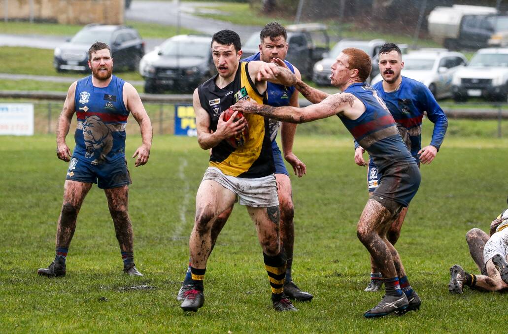 OUTTA MY WAY: Tiger Mikey Boyd charges past a pack of Bulldogs as rain falls at Panmure Recreation Reserve on Saturday. Picture: Anthony Brady