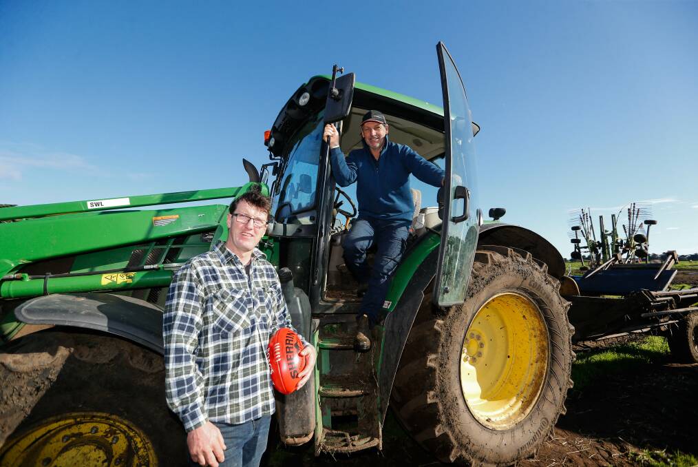 TEAM WORK: Cobden coach Adam Courtney and former Nirranda co-coach Shane Quick work together on a Glenormiston dairy farm. Picture: Anthony Brady 