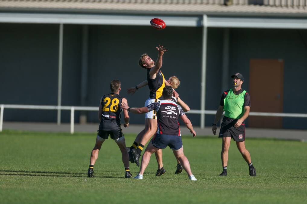 LEAP: Portland's Tom Sharp jumps for the ball during match simulation against Koroit as Saints coach Chris McLaren, in his role as umpire, watches on. Picture: Chris Doheny