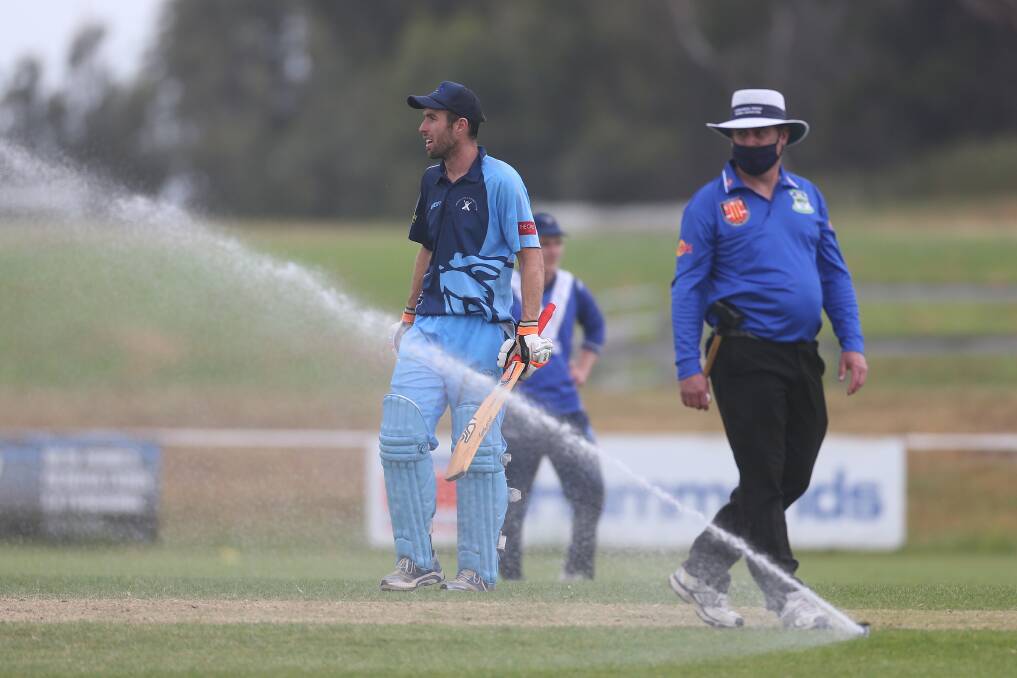 GAME OVER: Wesley-CBC's Ben Dobson and umpire Ashley Jennings were puzzled when the sprinklers turned on during a division one game. Picture: Mark Witte 