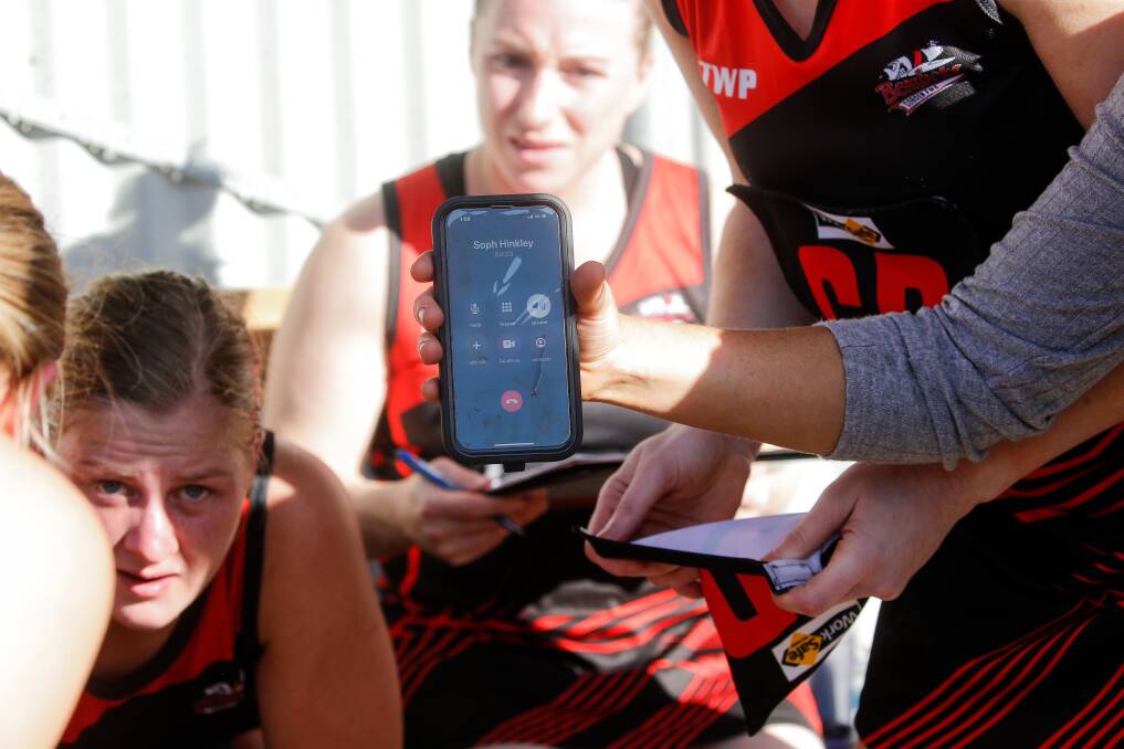 COACHING FROM AFAR: Players listen to Sophie Hinkley who was isolating with COVID-19. Picture: Anthony Brady 