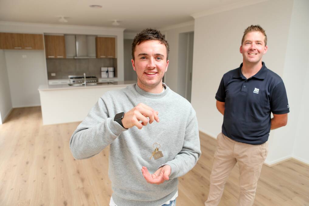 HOME SWEET HOME: First home buyer Bronte Baker in his new place with Metricon's Luke Malady. Picture: Chris Doheny