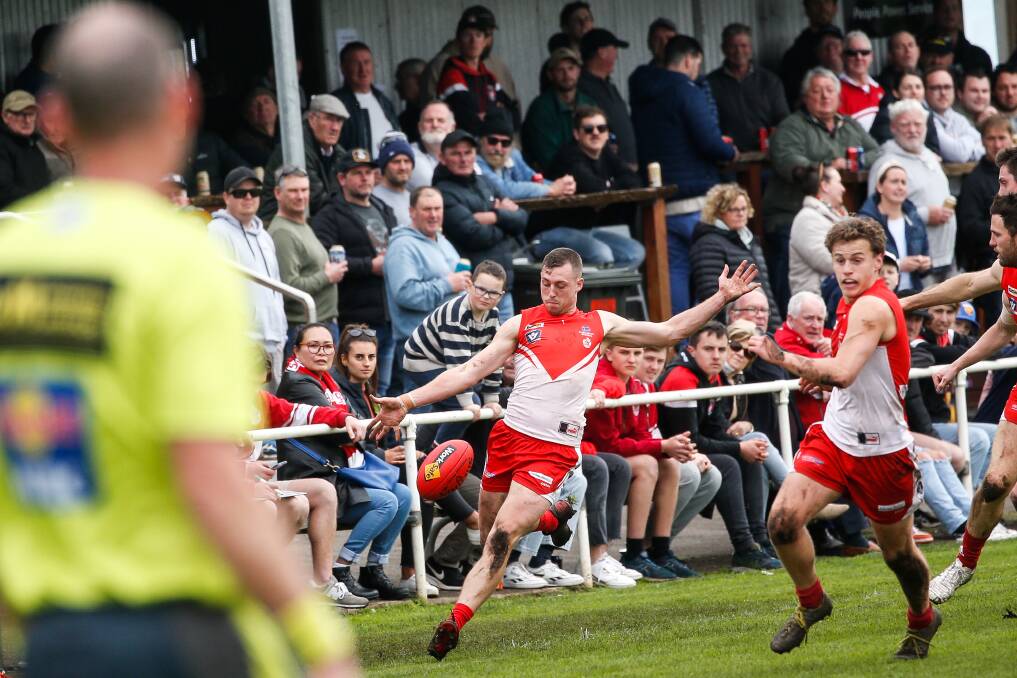 A large crowd watches South Warrnambool's Ben Rantall kick the Roosters forward. Picture by Anthony Brady 
