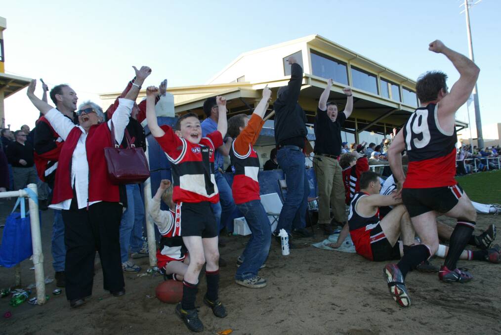REJOICE: Players and supporters celebrate on the sidelines after Koroit ended a 30-year premiership drought in 2003. 