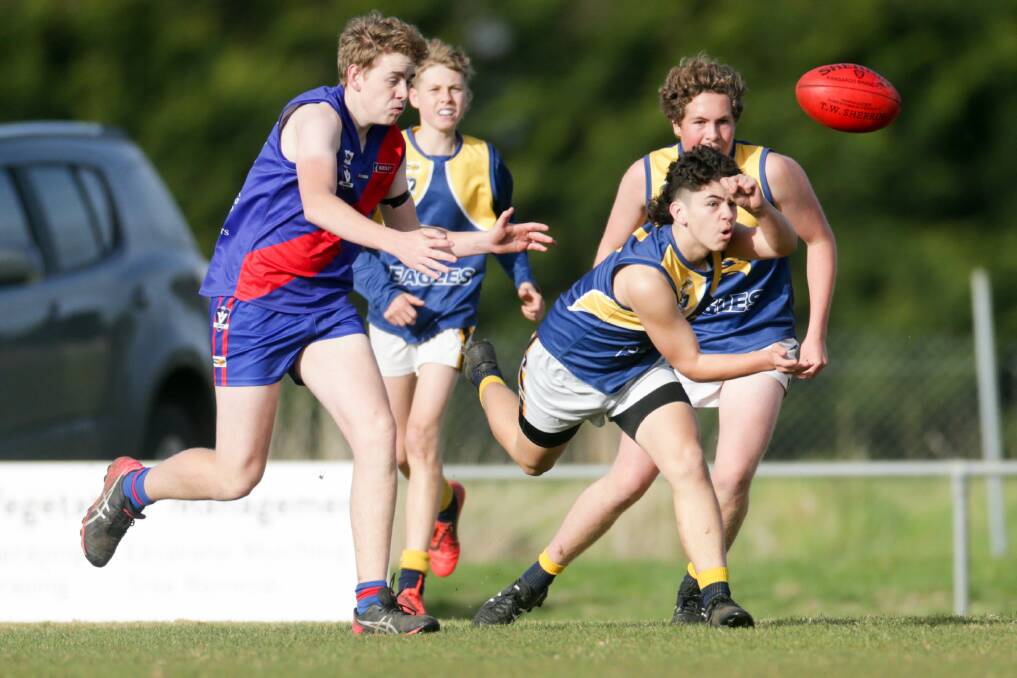 QUICK HANDS: Nathan Turner in action for North Warrnambool Eagles against Terang Mortlake in an under 16 football match earlier this season. The under 16s play on Sundays. Picture: Chris Doheny