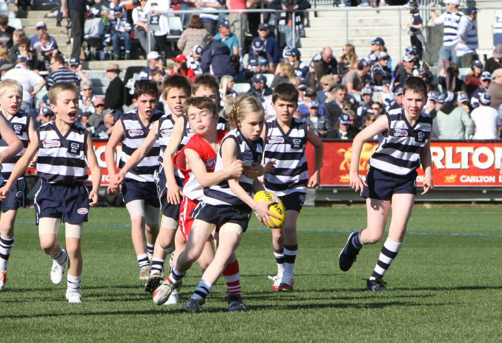 CATTERY: Renee Saulitis is tackled by Harry Hogan during an Auskick match at Geelong's Kardinia Park in 2012. 