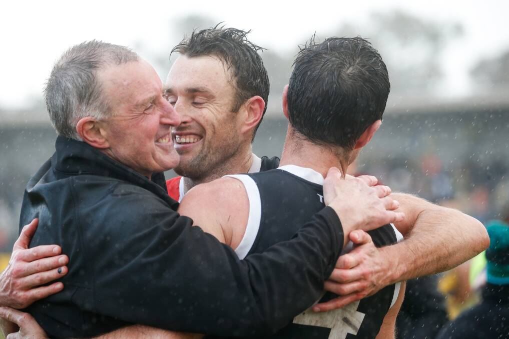 Proud dad Brendan Dobson embraces sons Sam and Ben after Koroit's grand final win. Picture by Anthony Brady 