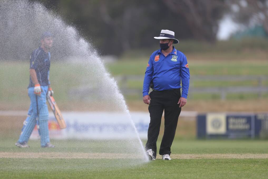 WATER WORKS: Umpire Ashley Jennings directs the sprinkler away from the Walter Oval pitch after it turned on. Picture: Mark Witte