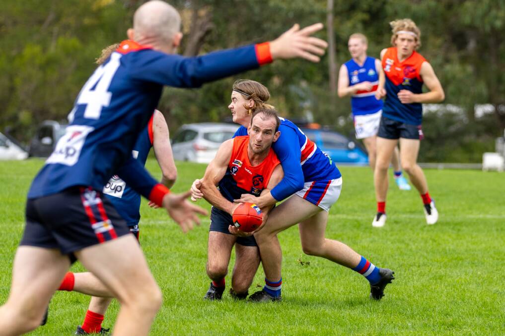 Timboon Demons' Ash Hunt tries to dish out a handball under pressure from Panmure's Darcy Bourke during their round three Warrnambool and District league match. Picture by Eddie Guerrero 