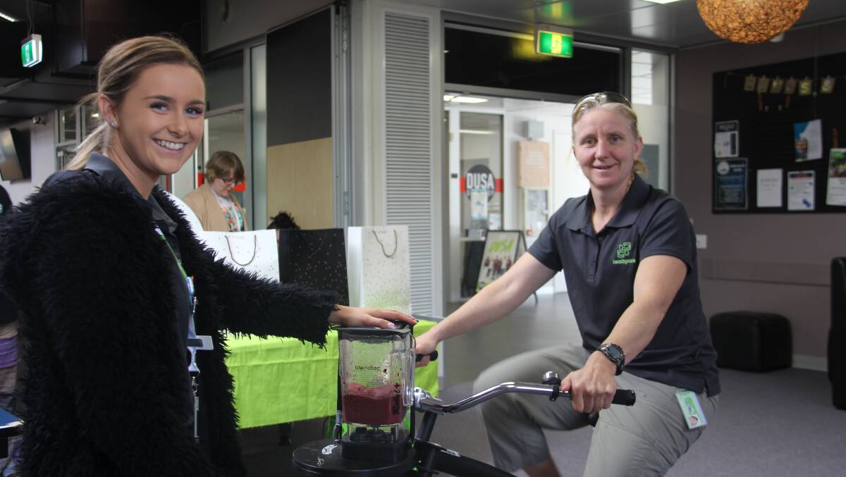 EAT WELL: headspace Warrnambool community awareness and engagement worker Kayla Mugavin and Maya Raschel ride to blend the smoothie bowl at Deakin University. Picture: Kimberley Price.