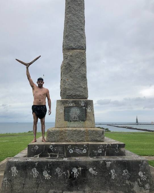 Christopher Saunders standing next to one of Portland's monuments to the Henty Brothers.