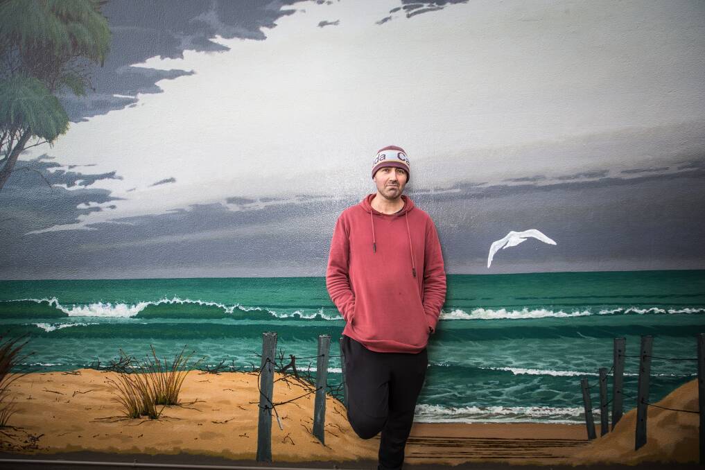 HEAD OUTSIDE: Artist Ricky Schembri at his 'Seascape' mural based on a selection of photos from Warrnambool's foreshore.