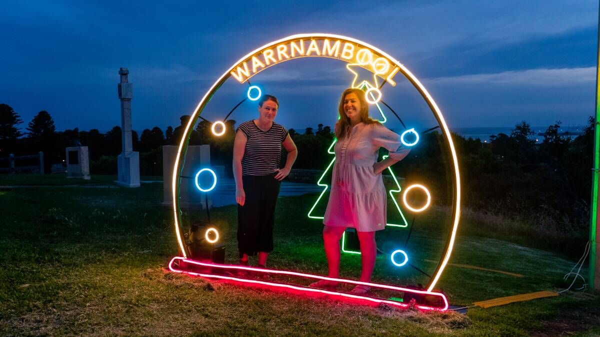 BRIGHT LIGHTS: Warrnambool City Council events manager Lauren Edney with artist Carla O'Brien with one to O'Brien's festive neon sculptures on display in Liebig Street and on Cannon Hill. 