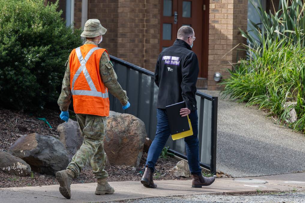 DOOR KNOCKING: Australian Army cavalryman Corporal Thomas Warren-Langford, from the 1st Armoured Regiment assists Department of Health and Human Services Victoria's authorised officer Martin Brennan with contact tracing and community engagement. 