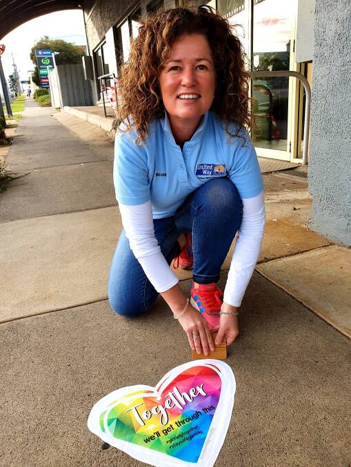 POSITIVE: United Way Glenelg executive officer Nicole Carr with one of the footpath decals popping up across Glenelg Shire. Picture: Supplied. 