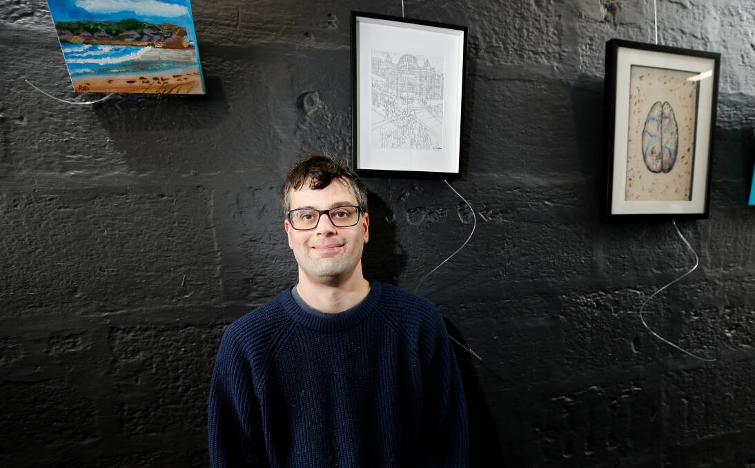 EXHIBIT: Studio A artist Sam Martina with his intricate drawing of Flinders Street Station. Picture: Anthony Brady.