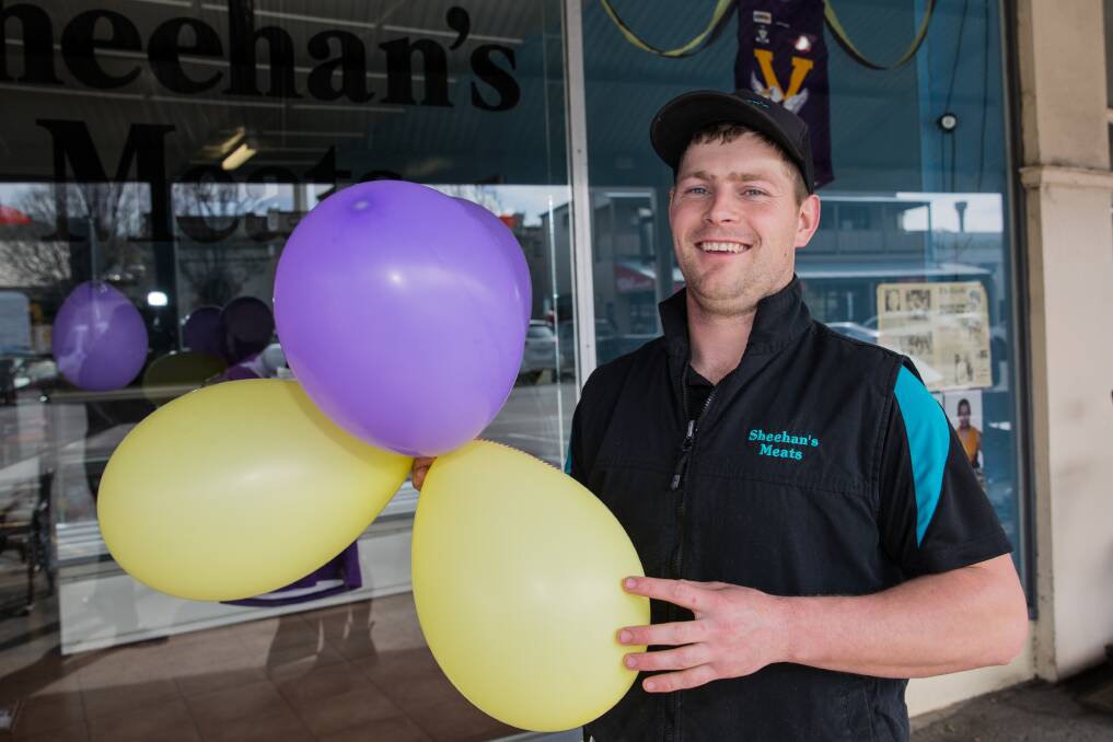 FLYING THE FLAG: Nick Sheehan outside Sheehan's Meats in the lead up to last year's HFNL grand final. 