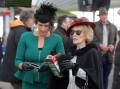 Sarah Porter and Karen Lathwell, both of Warrnambool, check the form books in the betting ring. Picture: Rob Gunstone
