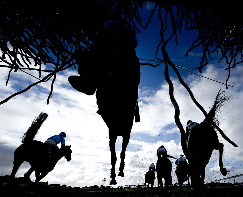 Race day: Horses leap over a jump during race six, the Thackeray Steeplechase. Picture: Morgan Hancock 