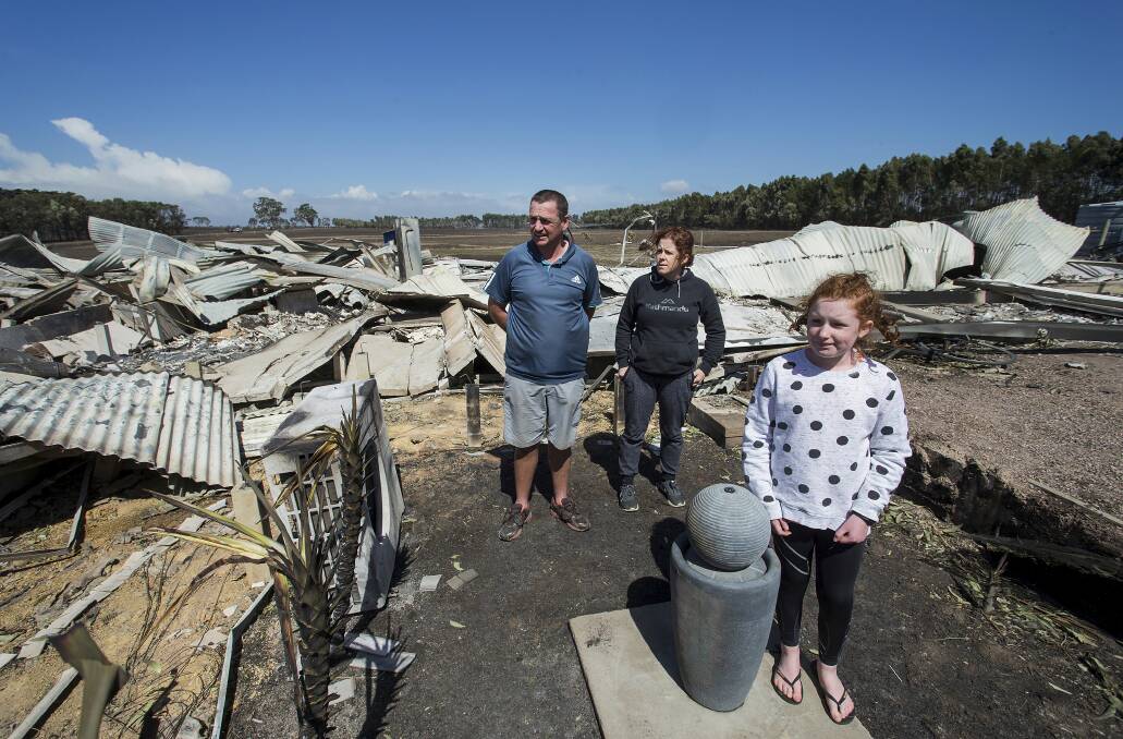 Phil and Maree Beasley with daughter Rose amongst the wreckage of the home which was destroyed in the fires at Terang. Picture: Paul Jeffers 
