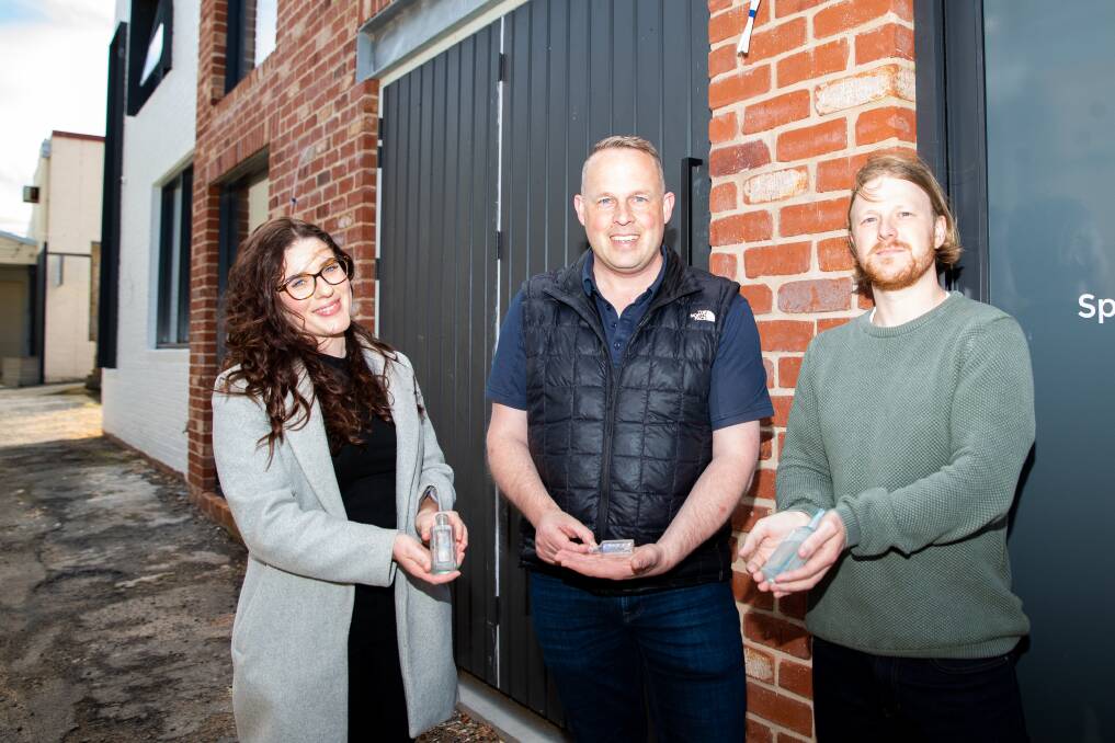 Emily Martini, Steve Myers and Luke Hayward with the pharmacy bottles that were found onsite when construction began on the new building in Ozone car park. Picture by Eddie Guerrero