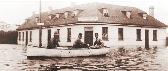 A boat rows down the street in Port Fairy during the 1946 floods.