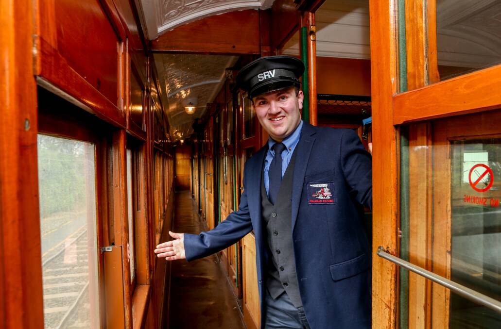 Luxury: Train officer Aysen Hassan aboard a vintage 1906-era red rattler train carriage in Warrnambool.