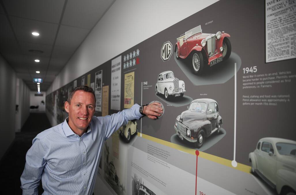 Steve Callagahan with the history board at Callaghan Motors which traces the history of the company which includes the last time they sold MGs. Picture: Morgan Hancock