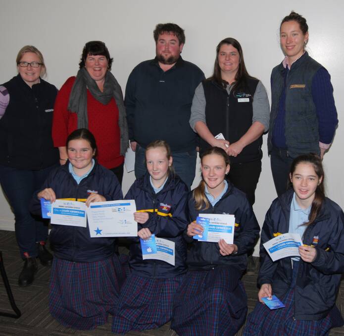 Joint first-prize winners from Timboon P-12 School receive their award from dairy industry representatives.