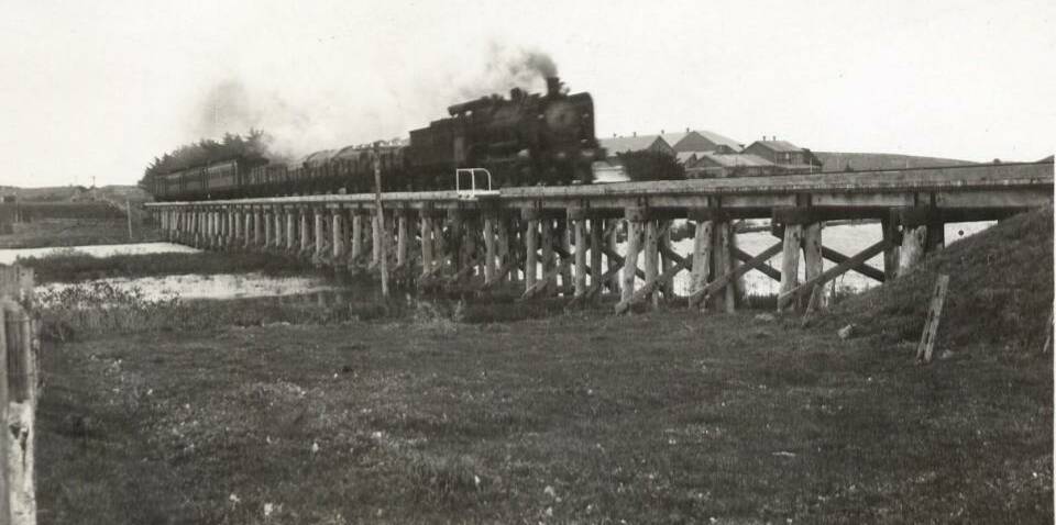 The steam train crossing railway bridge in about 1950 with goods trucks and passenger carriages. The bridge opened in 1890 and closed in 1977.