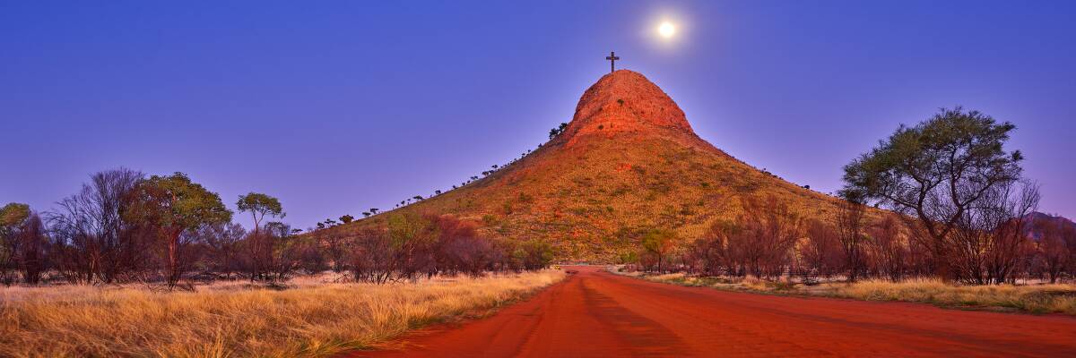 The local indigenous community has erected a giant 20-metre high cross atop Memory Mountain. Picture by Ken Duncan