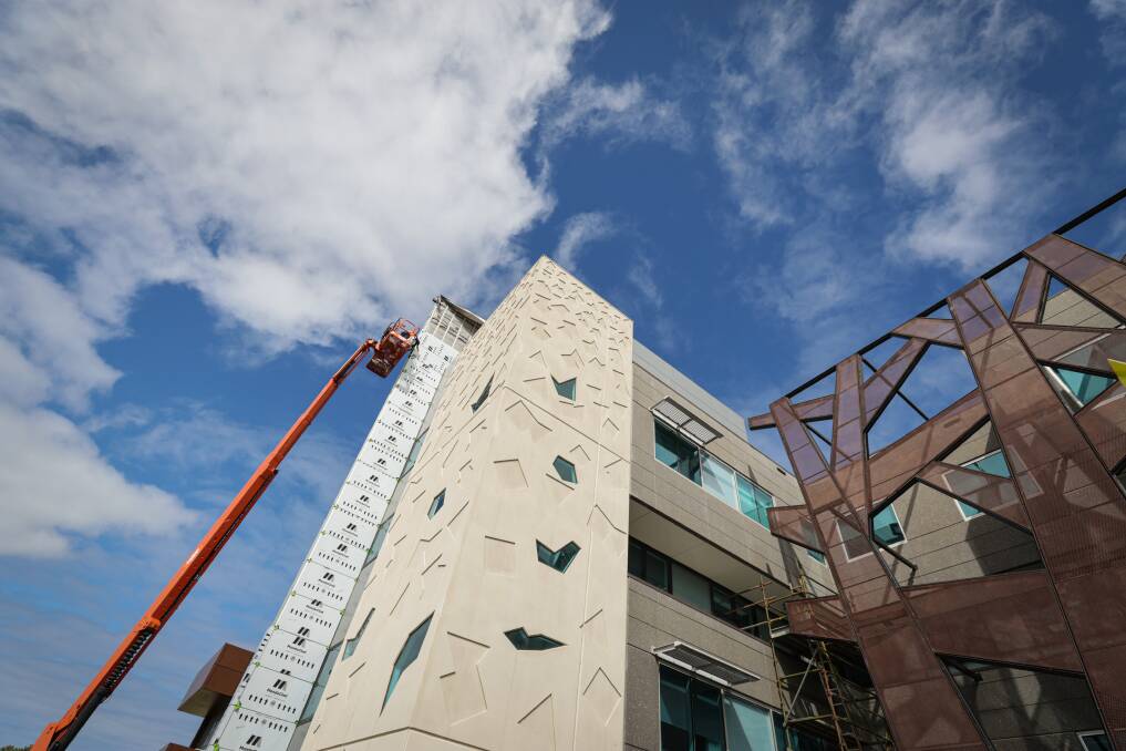 Workers are replacing the cladding on the outside of the newer part of Warrnambool's hospital. Picture by Sean McKenna