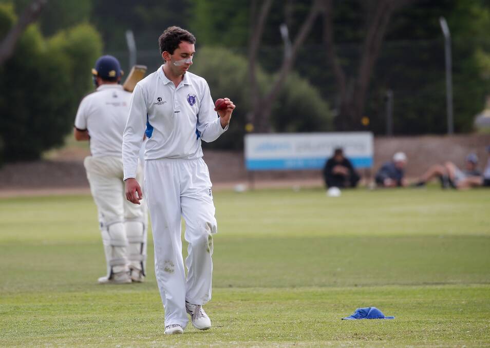 Blake Evans inspects the ball before bowling a delivery. Picture: Anthony Brady