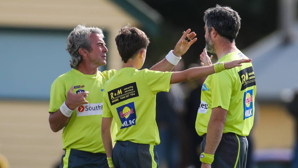 LIKE A TEAM: Umpires discuss a call on-field. Picture: Morgan Hancock