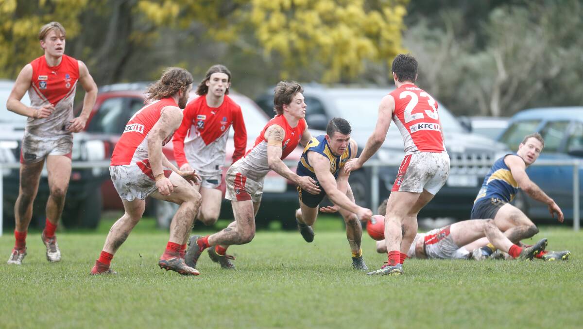 CHARGING THROUGH: North Warrnambool Eagles' Jarryd Lewis bursts through a pack of South Warrnambool players. Picture: Mark Witte
