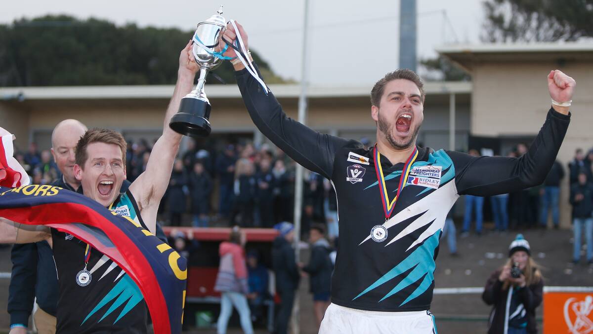 HAPPY TIMES: Kolora-Noorat's Jake Richardson (right) raises the premiership cup with coach Ben Walsh last season. Richardson was voted the Warrnambool and District league's best defender of the last five years. Picture: Mark Witte
