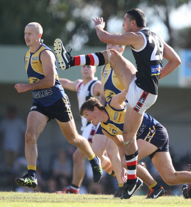 Koroit's Jarrod Korewha sends the ball inside 50 under pressure from North Warrnambool opponents. Picture: Nick Ansell