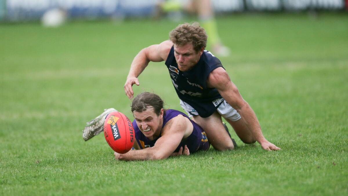COMPETING: Warrnambool's Jye Turland works to grab the ball from Port Fairy's Isaac Martin. Picture: Chris Doheny