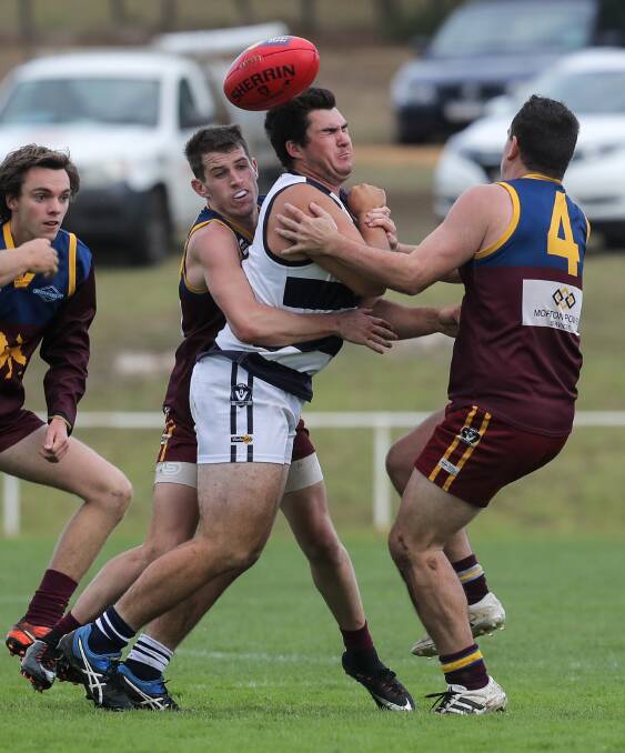 CRUNCHED: Allansford's Dalton Pincott is wrapped by a band of South Rovers midfielders in the Cats' 23-point loss on Saturday. Picture: Rob Gunstone