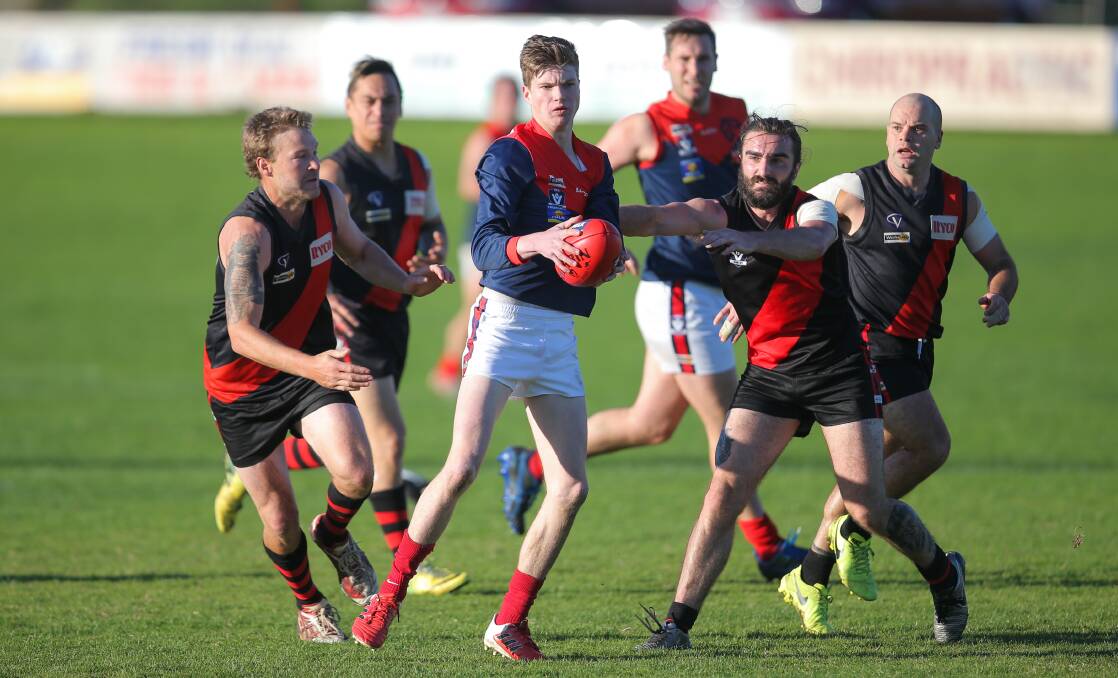 THE HUNTED: Timboon's Bayley Thompson keeps his eyes forward under pressure from East Warrnambool's Jayden Millet. Picture: Morgan Hancock