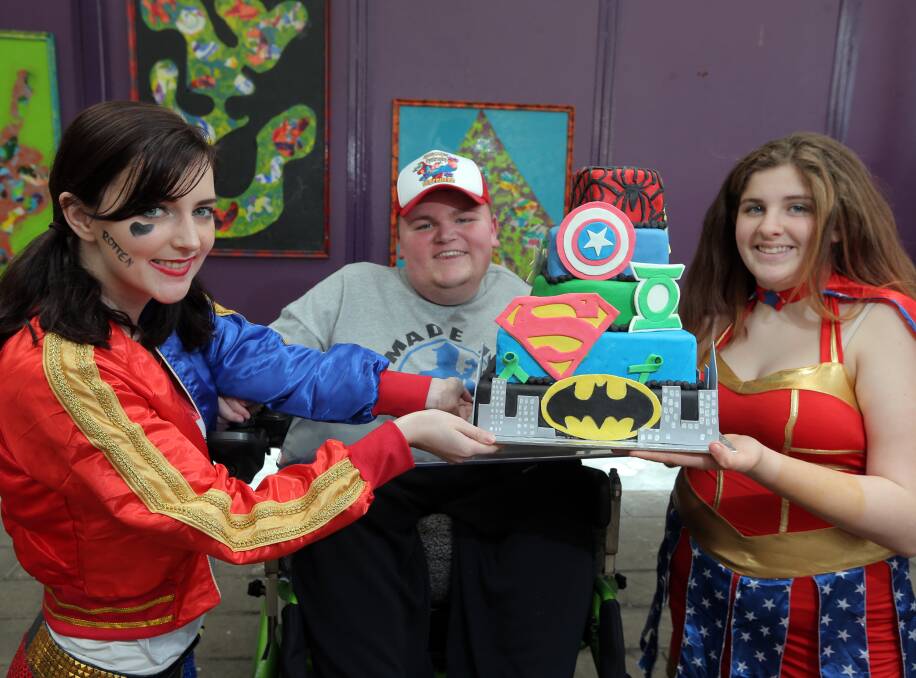 Superhero Day: Brauer College students Brianna Mansridge, 18, and Amy Buck, 13, help raise money for equipment for Chris Gillin (centre). Picture: Rob Gunstone