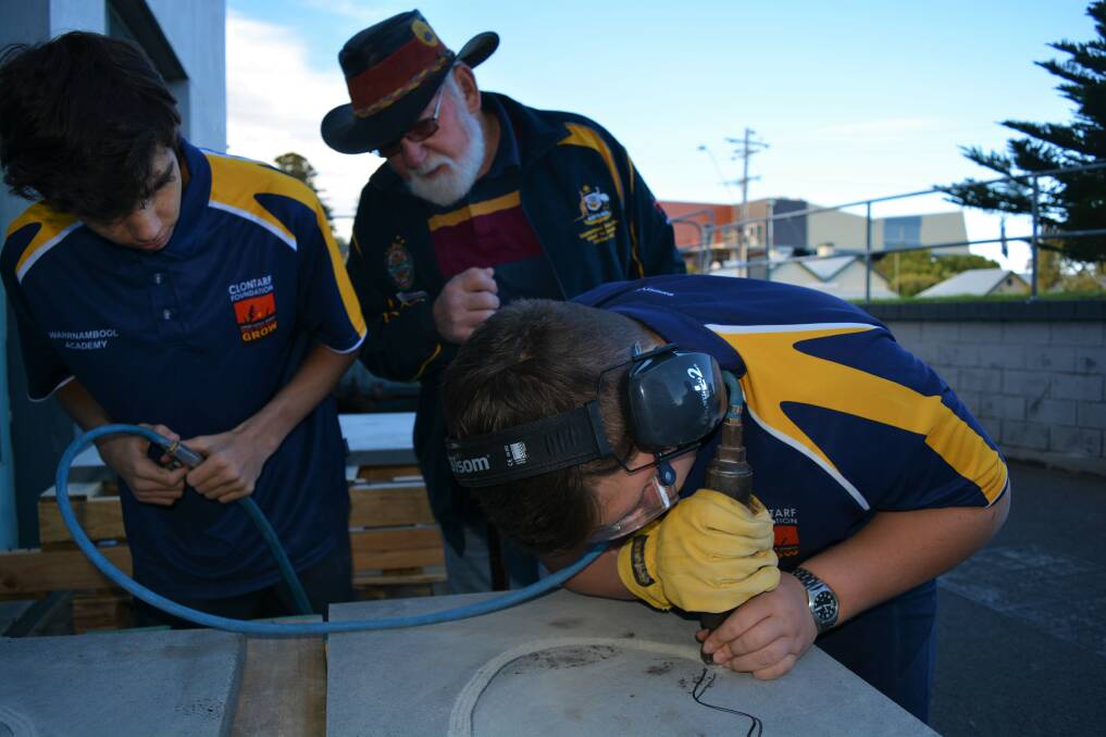 Welcome: Warrnambool Clontarf Academy's Jordon Chivers, 15 and Isaac Dalton, 13 are etching for SW TAFE under the guidance of Indigenous Elder Uncle Rob Lowe.